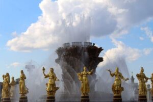Stunning fountain with golden statues under a blue sky at VDNKh, showcasing artistic craftsmanship.